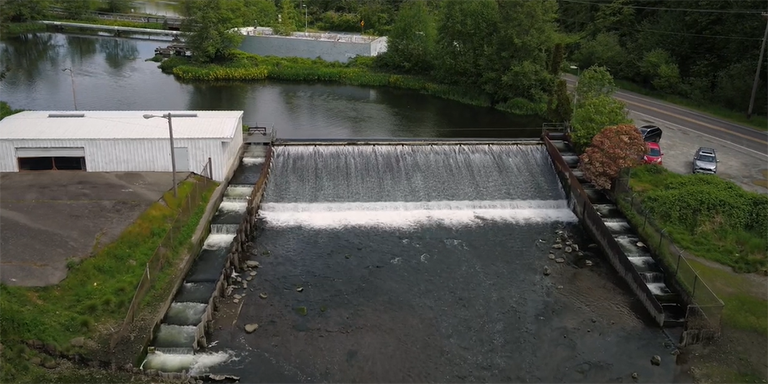 Screenshot from video about barriers to fish passage, showing an overhead shot of Chambers Creek Dam
