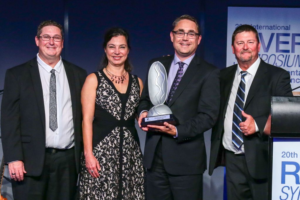 Photo of Steven Schauer, the author of this article, and other standing together while Schauer holds an award, the International Riverprize, in his hands.