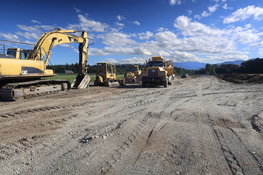 Excavator, skid steer, bulldozer, and other construction equipment at a restoration site.